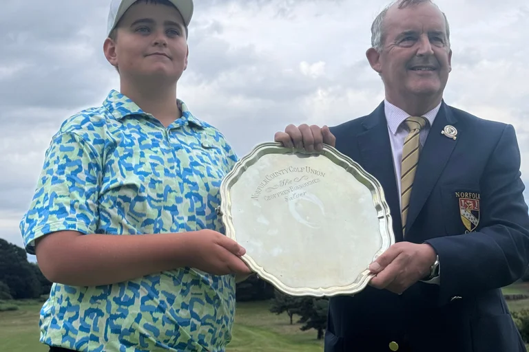 Norfolk Handicap Championship winner Jack Johnson receives the Geoffrey Burroughs Salver from Norfolk County Golf Union president Stuart Goodman